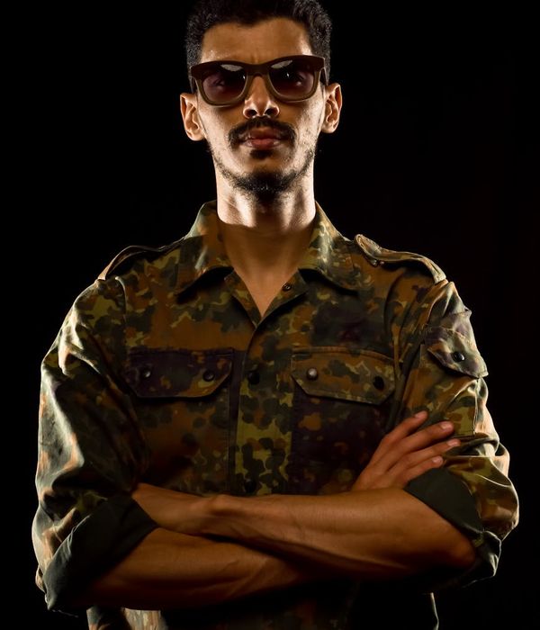 Man in a powerful focused stance against a dark background.